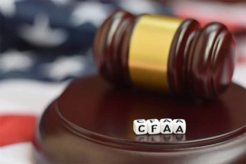 An image featuring a gavel with dices that say CFAA representing the computer fraud and abuse act of 1986 concept