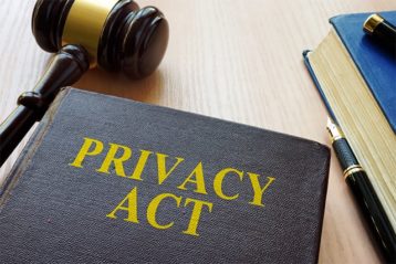 An image featuring a book that says privacy act on it with a gavel next to it representing privacy act rules