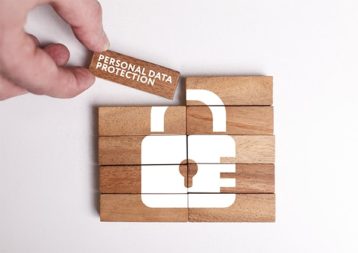 An image featuring a person holding a wooden rectangle that says personal data protection on it representing data privacy