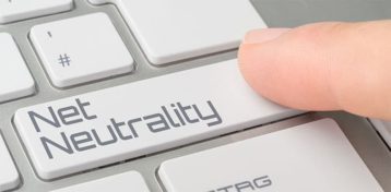 An image featuring a person pressing the enter button that has a text that says net neutrality